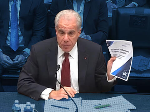 PRAC Chair Michael Horowitz holding the Blueprint 